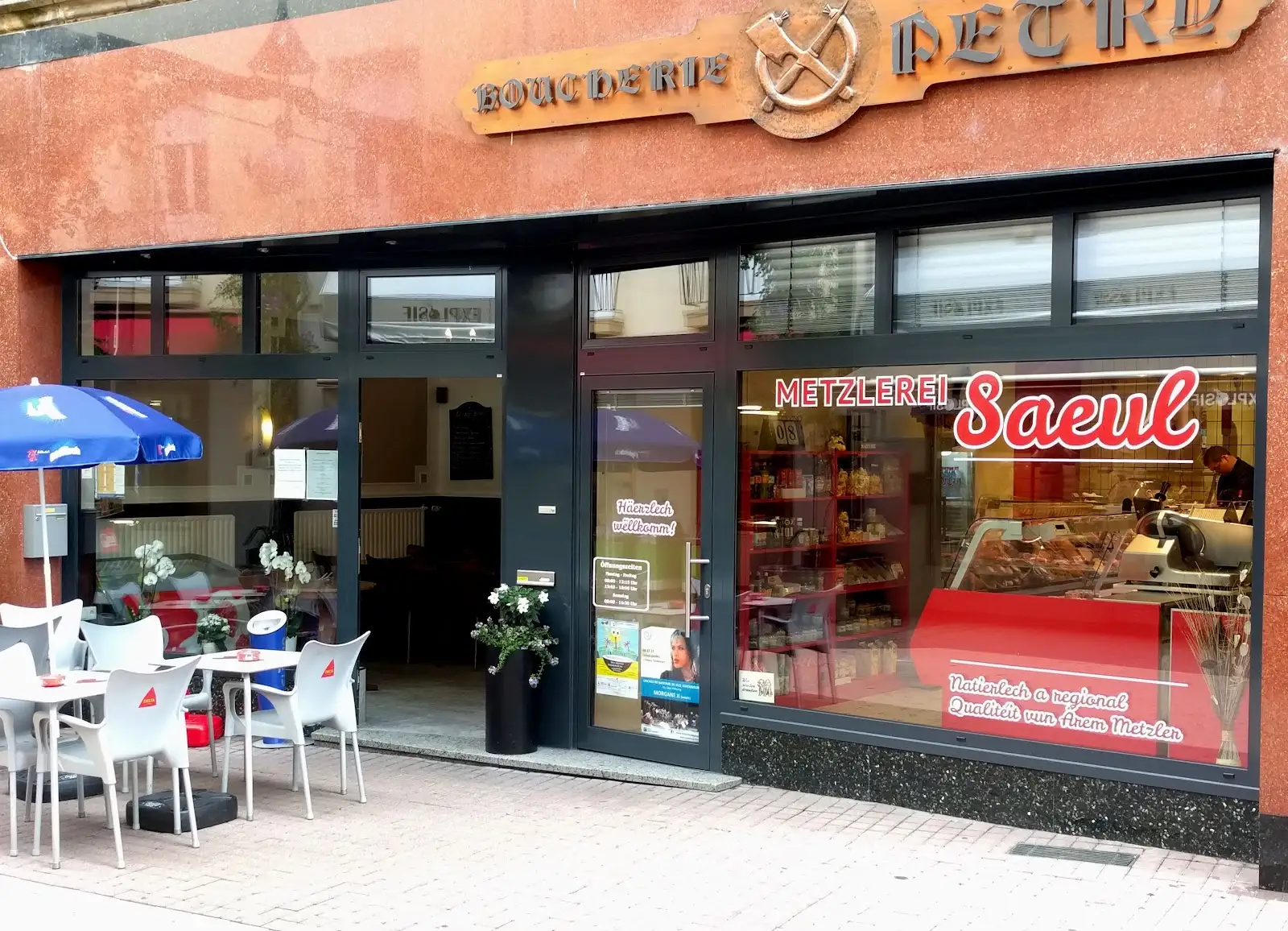 Devanture de la Metzlerei Lucien Saeul Sàrl dans la zone piétonne d'Echternach, avec terrasse et enseigne rouge Saeul